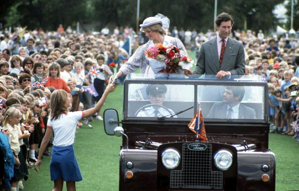 <p>Diana receives flowers from a fan as she and Charles ride through Hands Oval in Bunbury.<br></p>