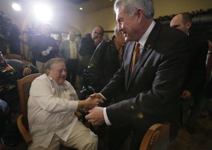 Texas coach Mack Brown, right, reaches out to long-time Texas booster Red McCombs, left, following a Valero Alamo Bowl news conference, Thursday,  Dec. 12, 2013, in San Antonio. Texas and Oregon will play in the NCAA college football game Dec. 30. (AP Photo/Eric Gay)