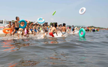 Schoolchildren play in the water at Songdowon International Children's Camp in Wonsan City, North Korea in this undated photo released by KCNA. KCNA/via REUTERS