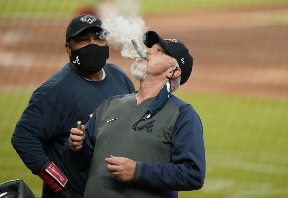 The Atlanta Braves pitching coach Rick Kranitz lights a cigar in celebration after a baseball game to clinch the NL East title against the Miami Marlins on Tuesday, Sept. 22, 2020, in Atlanta. (AP Photo/Brynn Anderson)