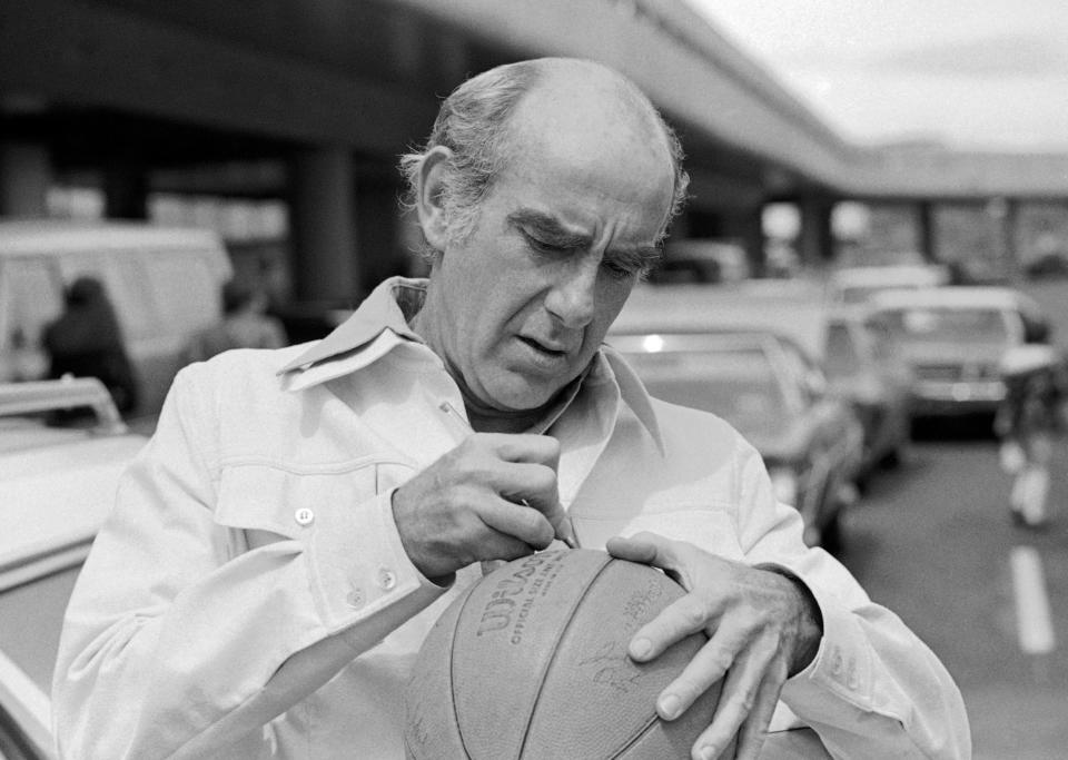 FILE - In this Friday, May 28, 1977, file photo, Portland Trail Blazers head coach Jack Ramsay autographs a basketball as the team arrived in Portland, Ore., as the trail Blazers trail the Philadelphia 76ers two games to none in their best of seven series for the NBA basketball title. Ramsay, a Hall of Fame coach who led the Portland Trail Blazers to the 1977 NBA championship before he became one of the league's most respected broadcasters, has died following a long battle with cancer. He was 89. (AP Photo/File)