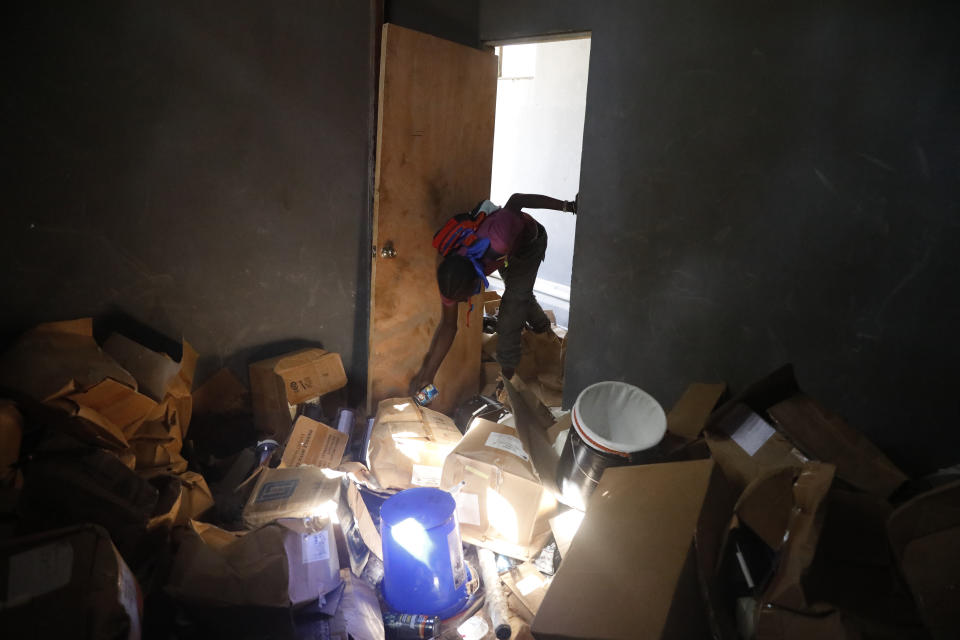 El trabajador de un hospital busca objetos que valga la pena recuperar de un almacén de alimentos en el Centro Hospitalario Fontaine un día después de que fue saqueado durante un ataque armado, el jueves 16 de noviembre de 2023, en la zona de Cité Soleil, de Puerto Príncipe, Haití. (AP Foto/Odelyn Joseph)