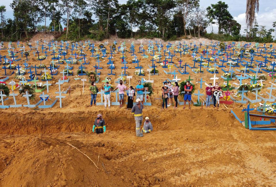 TOPSHOT - Aerial picture showing a burial taking place at an area where new graves have been dug up at the Nossa Senhora Aparecida cemetery in Manaus, in the Amazon forest in Brazil, on April 22, 2020. - The new grave area hosts suspected and confirmed victims of the COVID-19 coronavirus pandemic. More than 180,000 people in the world have died from the novel coronavirus since it emerged in China last December, according to an AFP tally based on official sources. (Photo by Michael DANTAS / AFP) (Photo by MICHAEL DANTAS/AFP via Getty Images)