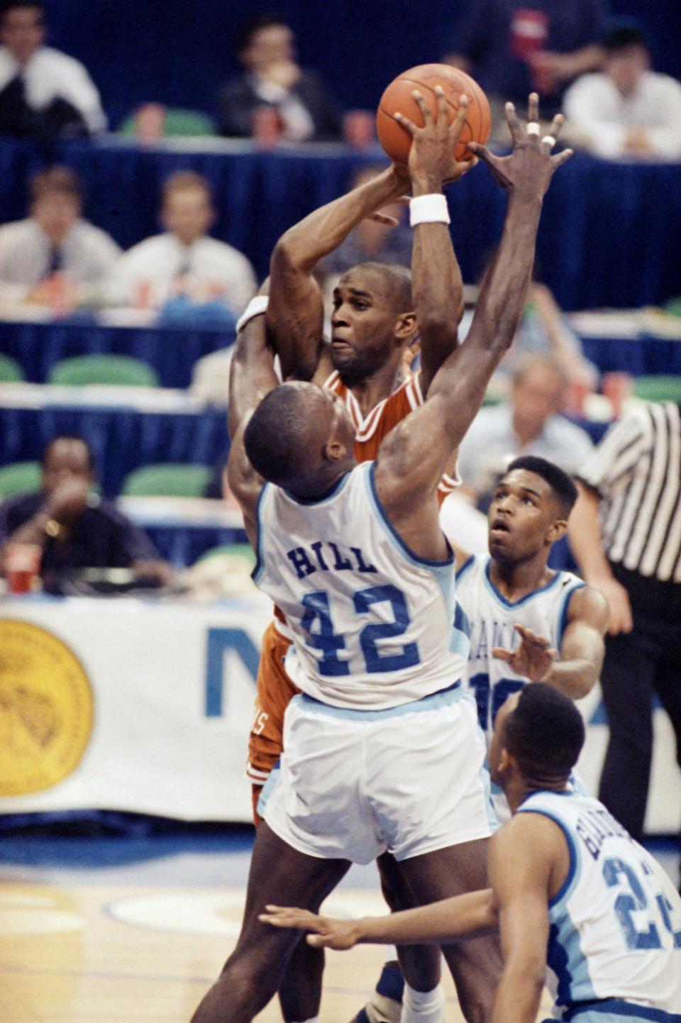 University of Texas guard Lance Blanks looks to pass as Xavier's Tyrone Hill (42) and Jamal Walker, right, try to block him during the first half of their NCAA Midwest Regional Tournament game in Dallas, March 22, 1990.