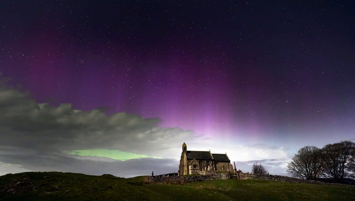 The aurora borealis over St Aidan’s church in Thockrington, Northumberland (PA)