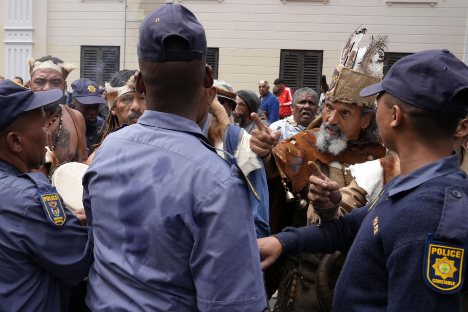 Khoisan protesters argue with police during the visit of King Willem Alexander and Queen Maxima of the Netherlands at the Slave Lodge in Cape Town, South Africa, Friday, Oct. 20, 2023. The king and queen of the Netherlands were confronted by angry protesters in South Africa on a visit Friday to a monument that traces part of their country's involvement in slavery as a colonial power 300 years ago. (AP Photo/Nardus Engelbrecht)