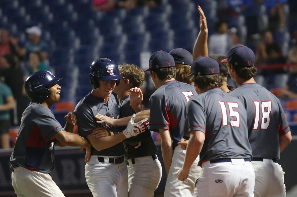 Hartley's Alex Blain is congratulated by teammates after scoring a run in the state semifinal.