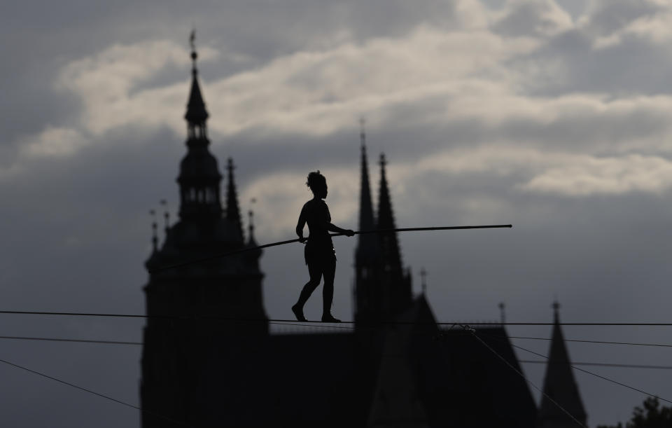 French tightrope walker Tatiana-Mosio Bongoga balances over the Vltava river during her performance to open an international new circus festival in Prague, Czech Republic, Wednesday, Aug. 14, 2019. The Prague Castle is in the background. (AP Photo/Petr David Josek)