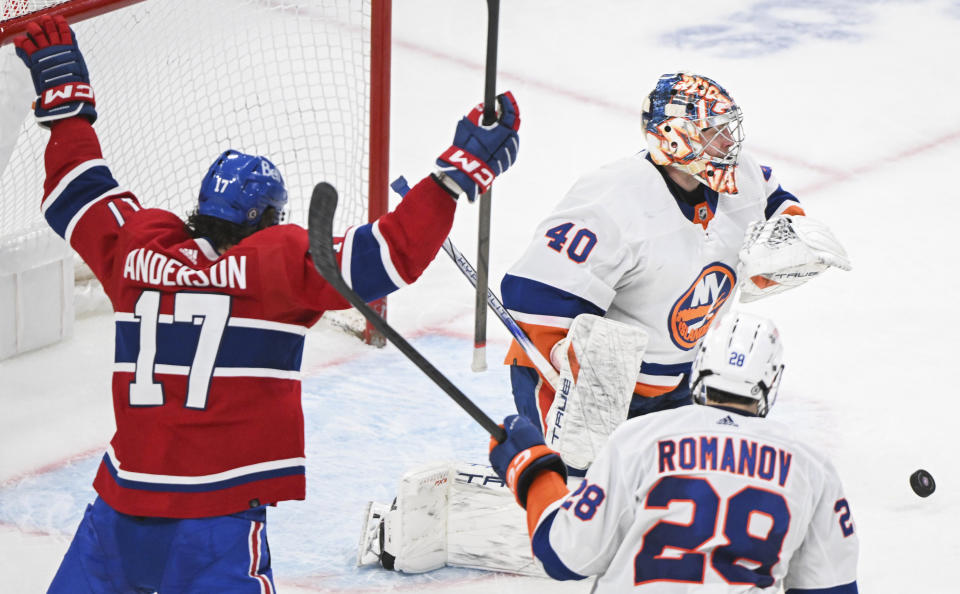 Montreal Canadiens' Josh Anderson reacts to a goal by Sean Monahan against New York Islanders goaltender Semyon Varlamov, while Islanders' Alexander Romanov (28) looks on during the third period of an NHL hockey game Thursday, Jan. 25, 2024, in Montreal. (Graham Hughes/The Canadian Press via AP)