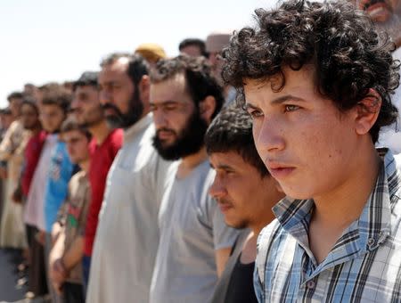 Islamic State prisoners, who were pardoned by a council that is expected to govern Raqqa once the group is dislodged from the Syrian city, stand in Ain Issa village, north of Raqqa, Syria June 24, 2017. REUTERS/Goran Tomasevic