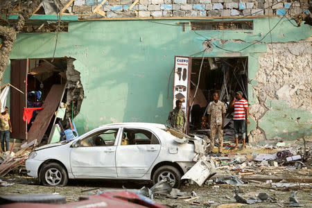 Somali security forces and civilians assess the damage at the scene of an explosion outside Weheliye Hotel in Maka al Mukarama street in Mogadishu, Somalia March 22, 2018. REUTERS/Feisal Omar