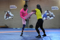 Guinean wrestler Fatoumata Yarie Camara, left competes with Italian athlete Morena De Vita during her morning training session at the Ostia's Olympic training center, near Rome, Monday, July 5, 2021. A West African wrestler's dream of competing in the Olympics has come down to a plane ticket. Fatoumata Yarie Camara is the only Guinean athlete to qualify for these Games. She was ready for Tokyo, but confusion over travel reigned for weeks. The 25-year-old and her family can't afford it. Guinean officials promised a ticket, but at the last minute announced a withdrawal from the Olympics over COVID-19 concerns. Under international pressure, Guinea reversed its decision. (AP Photo/Alessandra Tarantino)
