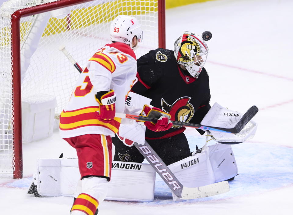 Ottawa Senators goaltender Matt Murray (30) looks for the puck as Calgary Flames centre Sam Bennett (93) moves towards the net during third period NHL hockey action in Ottawa on Monday, March 1, 2021. (Sean Kilpatrick/The Canadian Press via AP)