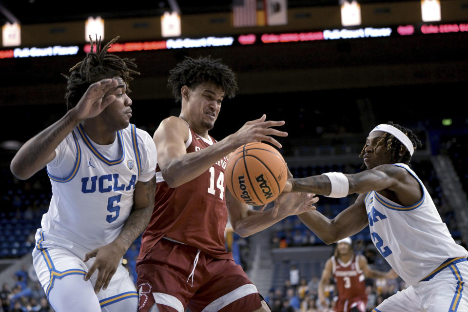 UCLA guard Brandon Williams, left, Stanford forward Spencer Jones (14) and UCLA guard Dylan Andrews (2) reach for the ball during the first half of an NCAA college basketball game Wednesday, Jan. 3, 2024, in Los Angeles. (AP Photo/Jayne Kamin-Oncea)