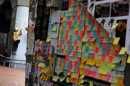 A worker cleans the wall of a pedestrian bridge in Hong Kong