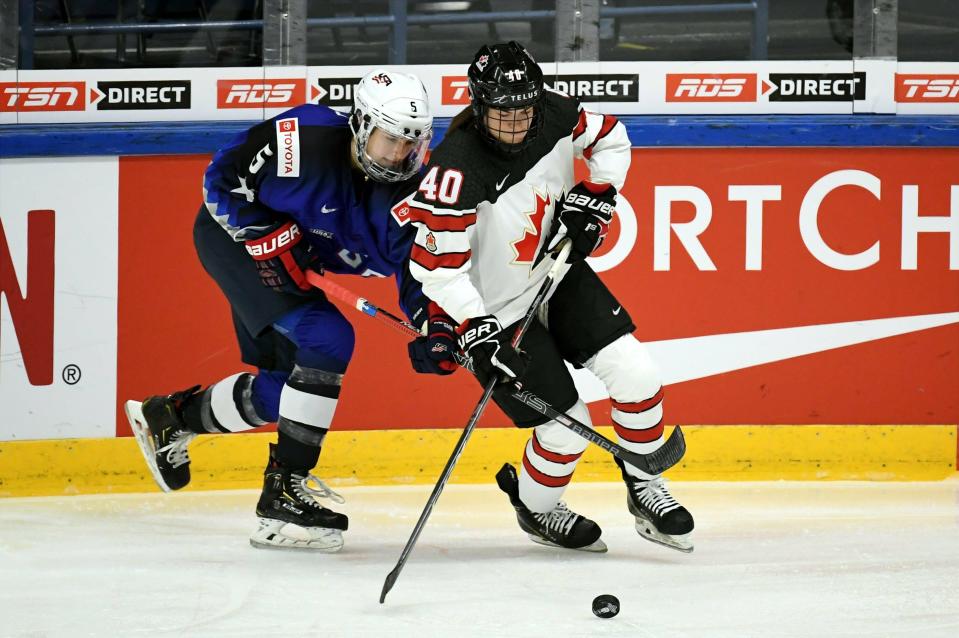 Megan Keller of USA, left, and Blayre Turnbull of Canada in action during the 2019 IIHF Women's World Championships preliminary match between USA and Canada in Espoo, Finland, Saturday April 6, 2019. (Antti Aimo-Koivisto/Lehtikuva via AP)