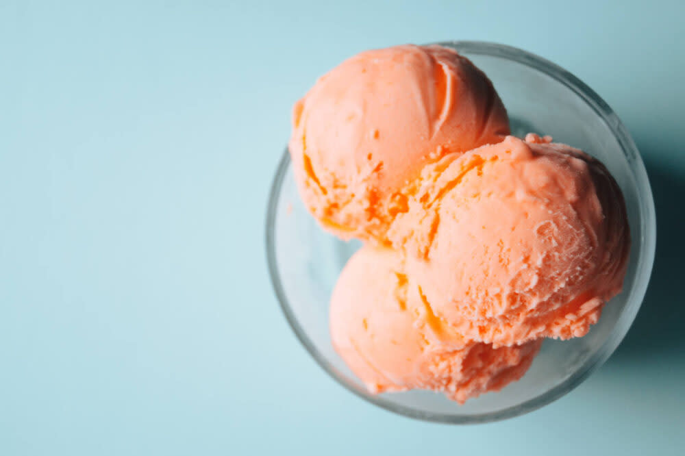 Scoops of orange sherbet in a bowl