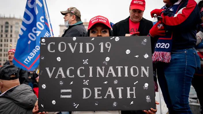 Una partidaria del presidente Donald Trump sosteniendo un cartel contra las vacunas, el 5 de enero en una protesta en la Freedom Plaza en Washington, D.C. (Erin Scott/Bloomberg vía Getty Images)
