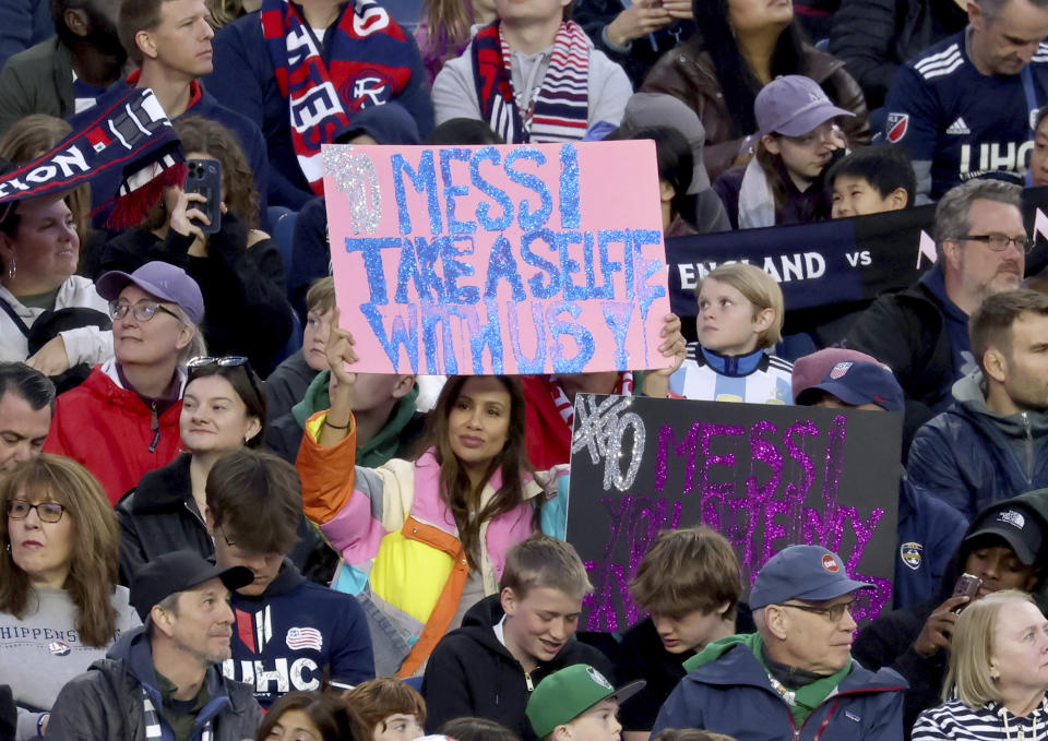Fans of Inter Miami forward Lionel Messi hold up signs during an MLS soccer match against the New England Revolution, Saturday, April 27, 2024, in Foxborough, Mass. (AP Photo/Mark Stockwell)