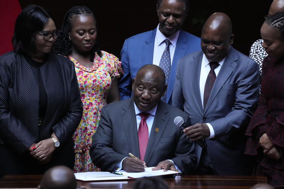 South African President Cyril Ramaphosa signs a bill for National Health Insurance signed into law in Pretoria, South Africa, Wednesday, May 15, 2024. Ramaphosa on Wednesday signed into law a new health bill that aims to overhaul the country's healthcare system but is set to face legal challenges from opposition parties. (AP Photo/Themba Hadebe)