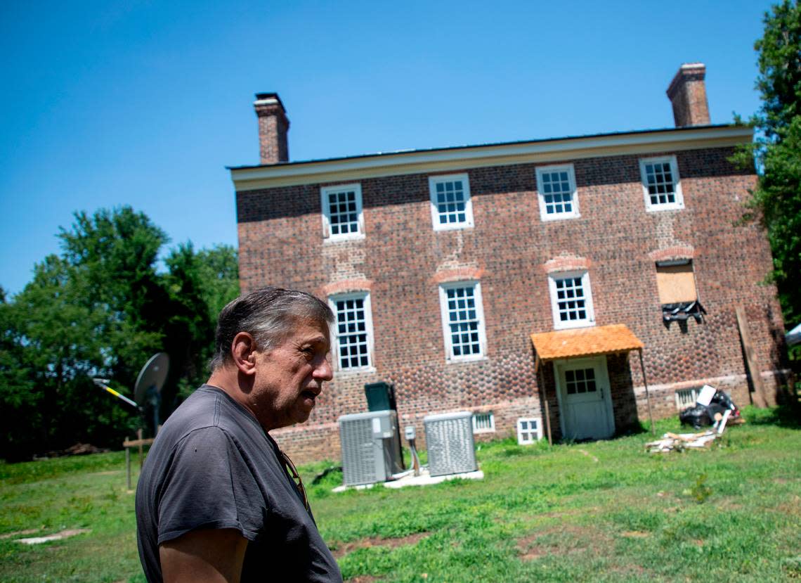 Bob Tucci walks along the exterior of the Duke-Lawrence House outside Rich Square, N.C., on June 15, 2022. Tucci is restoring the home, one of the oldest in North Carolina.