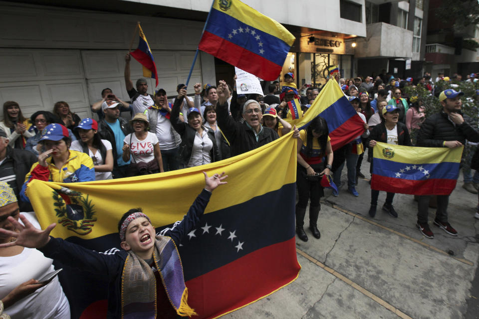 Venezuelans protest outside the Venezuelan embassy in Mexico City, Wednesday, Jan. 23, 2019. Venezuelan migrants held a rally against Venezuelan President Nicolas Maduro and in favor of Juan Guaido, head of Venezuela's opposition-run congress who today declared himself interim president of the South American nation. (AP Photo/Marco Ugarte)