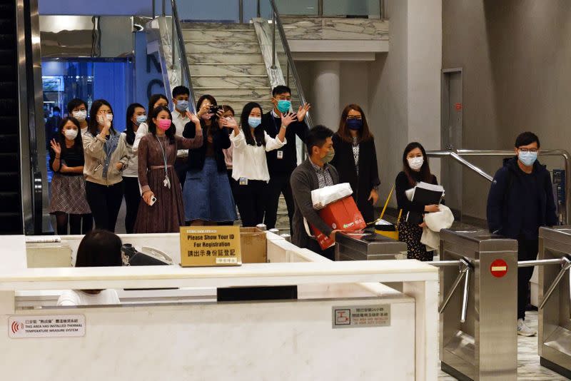 i-Cable TV news journalists leave with their boxes after being laid off in Hong Kong