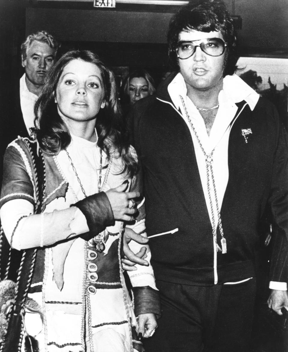 SANTA MONICA, CA - OCTOBER 9:  Rock and roll singer Elvis Presley and his wife Priscilla Beaulieu Presley leave the courthouse hand in hand following a short divorce hearing on October 9, 1973 in Santa Monica, California. (Photo by Michael Ochs Archives/Getty Images)