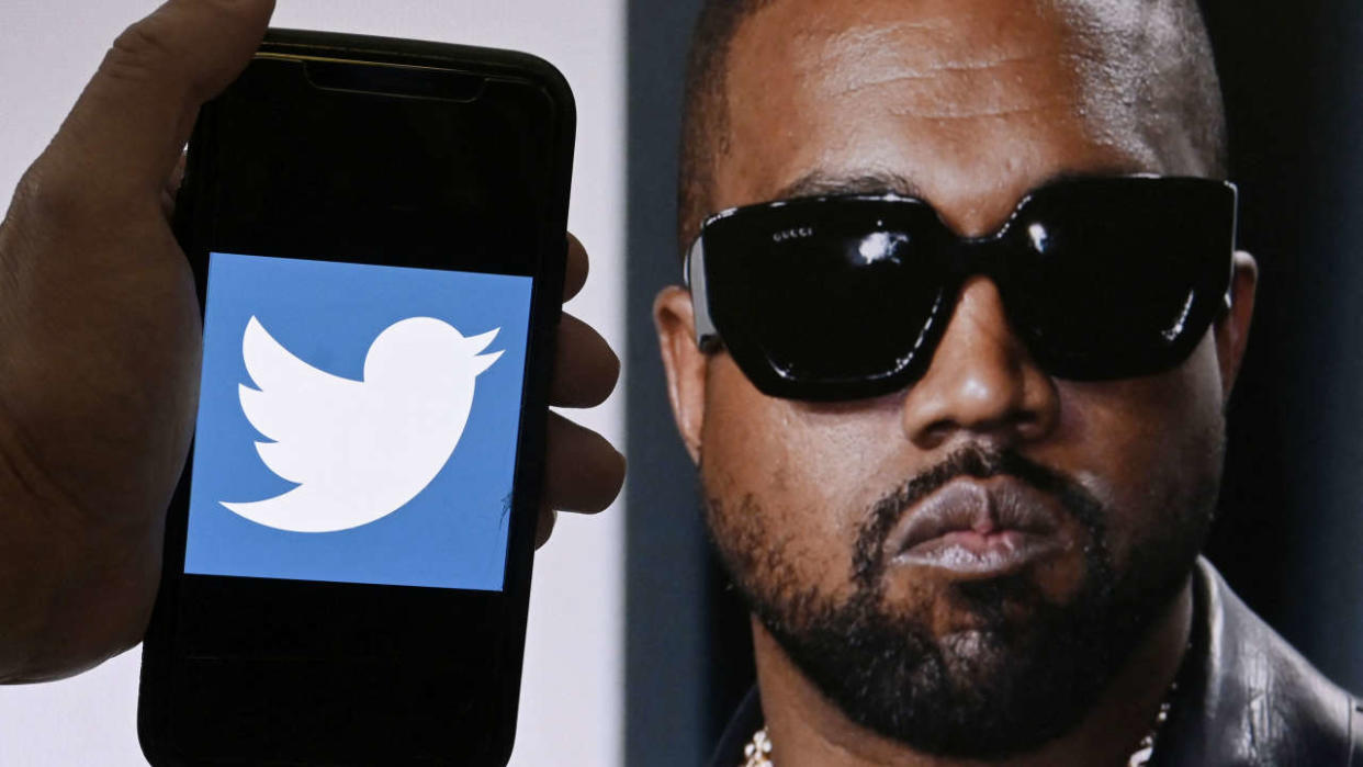 Montage AFP du logo Twitter affiché sur un téléphone portable avec une photo de Kanye West en arrière-plan, le 28 octobre 2022 à Washington, DC. 
(Photo : OLIVIER DOULIERY / AFP)
