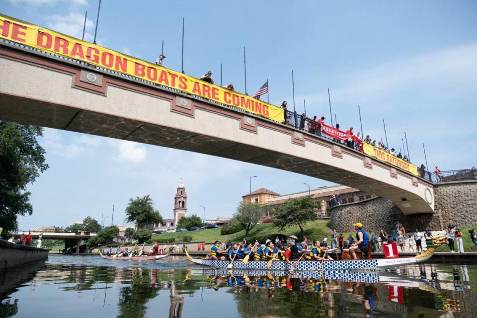 Dragon Boat race competitors row beneath Sister City Bridge Saturday on Bush Creek in Kansas City.