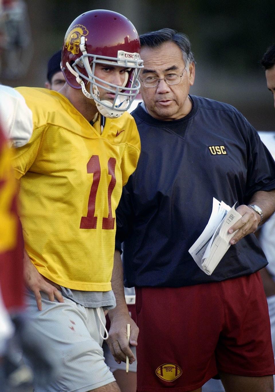 Norm Chow, offensive coordinator for the University of Southern California, talks with starting quarterback Matt Leinart during practice Tuesday, Nov. 4, 2003, on the campus in <a class="link " href="https://sports.yahoo.com/nfl/teams/la-rams/" data-i13n="sec:content-canvas;subsec:anchor_text;elm:context_link" data-ylk="slk:Los Angeles;sec:content-canvas;subsec:anchor_text;elm:context_link;itc:0">Los Angeles</a>. | Reed Saxon, Associated Press