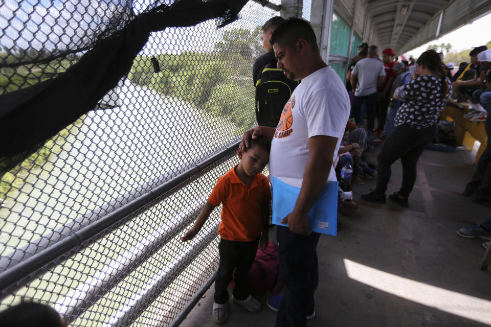 En esta foto del 10 de octubre de 2019, migrantes esperan a que autoridades estadounidenses reabran el punto de ingreso entre Matamoros, México, y Brownsville, Texas, después de que el puente fue cerrado brevemenre por las autoridaes de Estados Unidos debido a una protesta de algunos migrantes en el lado mexicano. La delincuencia organizada ha sabido adaptarse y aprovechar la presencia de los migrantes: familias enteras, muchas veces con niños, son tratadas como mera mercancía o cual cajeros automáticos andantes, listos para alimentar sus negocios criminales. (AP Foto/Fernando Llano)