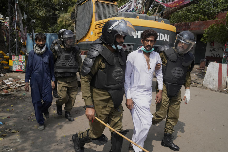 Police detain supporters of former Prime Minister Imran Khan during a search operation in the Khan's residence, in Lahore, Pakistan, March 18, 2023. Pakistani police stormed former Prime Minister Khan's residence in the eastern city of Lahore on Saturday and arrested 61 people amid tear gas and clashes between Khan's supporters and police, officials said. (AP Photo/K.M. Chaudary)