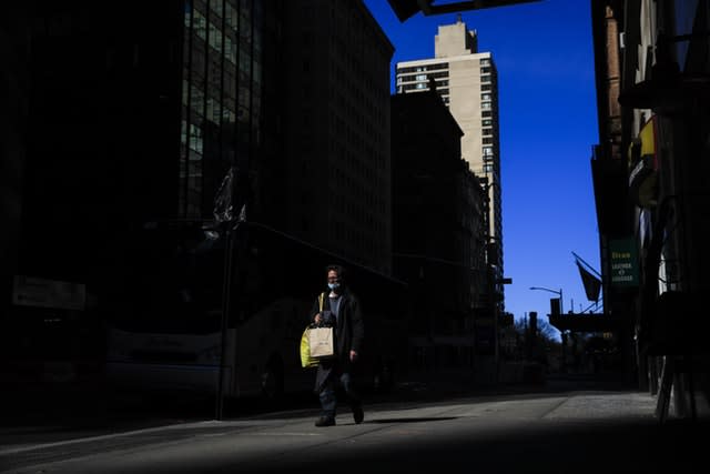 A person wearing a protective face mask walks in New York