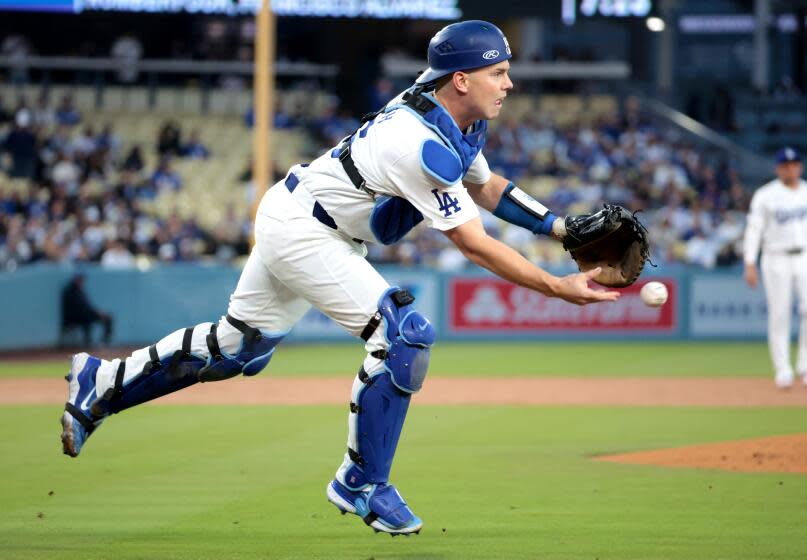 Dodgers catcher Will Smith throws the ball over the head of first baseman Freddie Freeman.