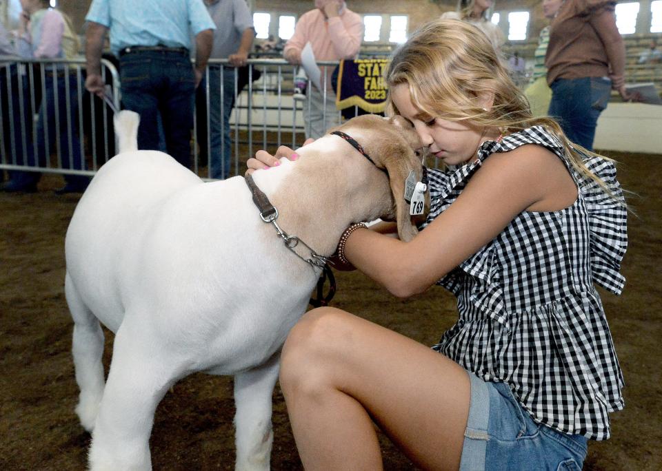 Nora Hoge, 8, of Good Hope, spends some time with Donnie, a Boer goat, at the Governor's Sale of Champion Wednesday, August 16, 2023.