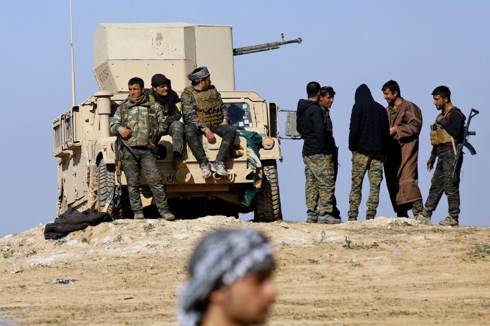 Fighters from the Syrian Democratic Forces (SDF) gather around a humvee armoured vehicle near the battered Islamic State-held holdout of Baghouz in the eastern Syrian province of Deir Ezzor (AFP/Getty Images)