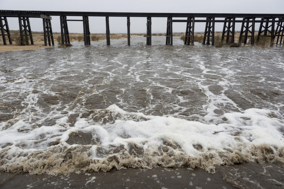 Water flows in the Mojave River after rain soaked Hesperia CA on Thursday January 17, 2019. The Mojave River flows under ground the majority of the year. (James Quigg/The Daily Press via AP)