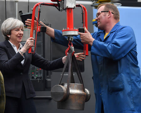FILE PHOTO: Britain's Prime Minister Theresa May uses a hand crane to move a component used in the oil and gas industry during a general election campaign visit to a tool factory in Kelso, Berwickshire, Scotland June 5, 2017. REUTERS/Ben Stansall/Pool/File Photo