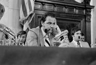 Sen. Fred Thompson, center, smokes a pipe as he listens to questions during the Senate Watergate Committee in Washington, July 11, 1973. Others are unidentified. (AP Photo)