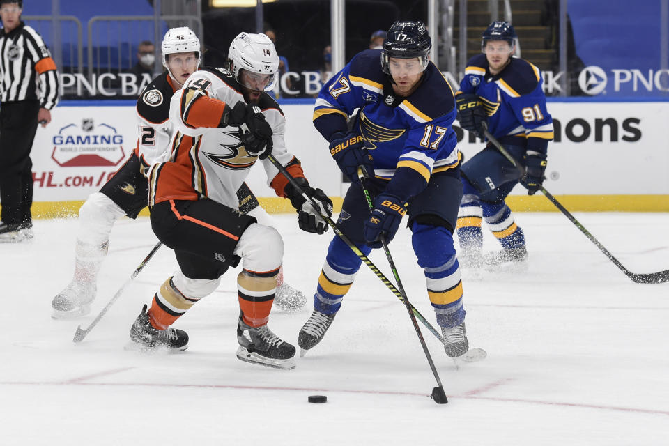 Anaheim Ducks' Adam Henrique (14) and St. Louis Blues' Jaden Schwartz (17) compete for the puck during the second period of an NHL hockey game Friday, March 26, 2021, in St. Louis. (AP Photo/Joe Puetz)