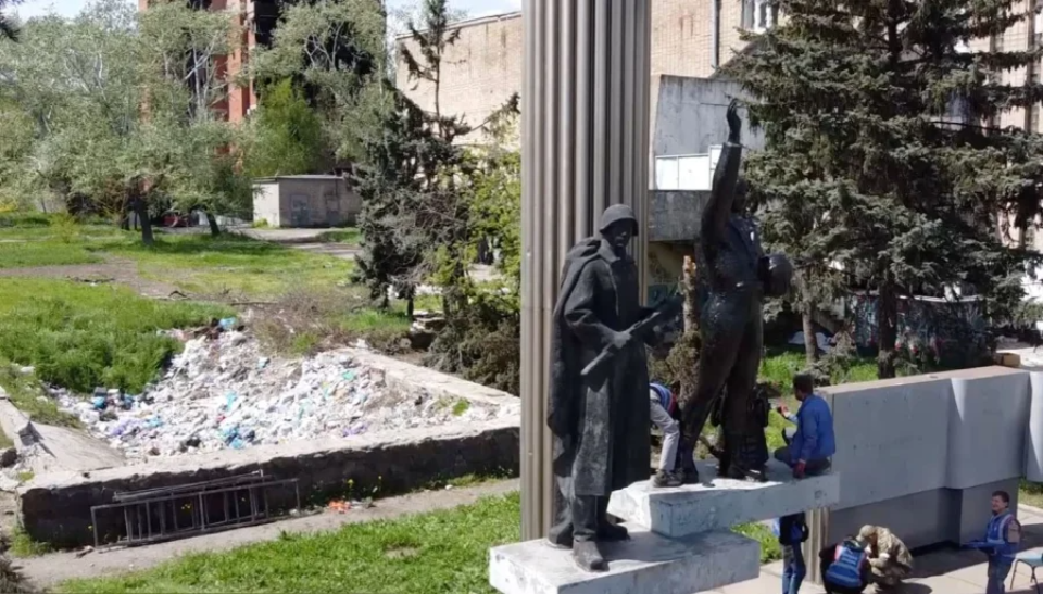 People tidy up a Soviet-era monument in Mariupol <span class="copyright">Petro Andriushchenko</span>