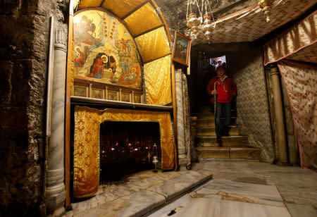 A visitor walks in the cave, where Virgin Mary is believed to have given birth to Jesus, inside the Church of the Nativity in the West Bank town of Bethlehem December 12, 2017. REUTERS/Mussa Qawasma