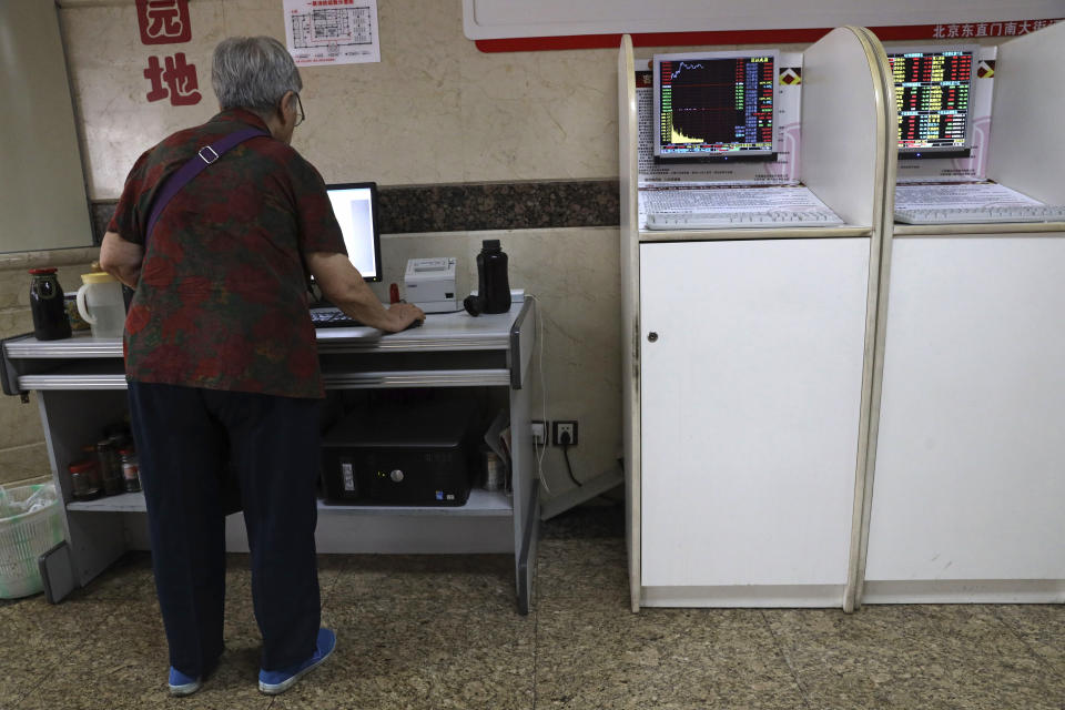 A Chinese woman check stock prices at a brokerage in Beijing on Friday, July 19, 2019. Asian shares rebounded Friday on hopes for progress in trade talks between China and the U.S., extending overnight gains on Wall Street. (AP Photo/Ng Han Guan)