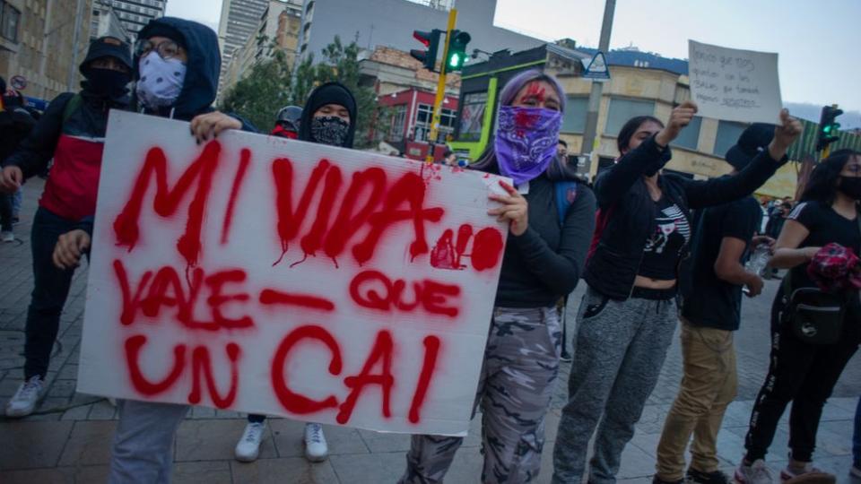 Manifestantes protestan con un cartel en contra de un CAI.