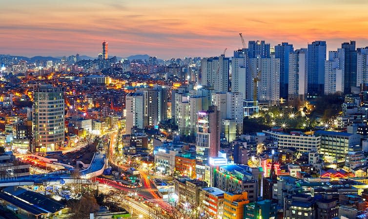 An aerial view of a city and traffic at sunset.