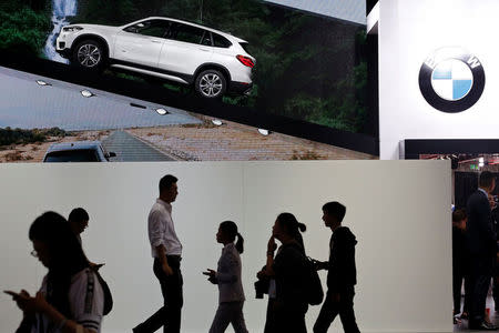 Visitors pass under a picture of the new BMW X1 xDrive25Li long wheelbase during Auto China 2016 auto show in Beijing, China April 25, 2016. REUTERS/Kim Kyung-Hoon