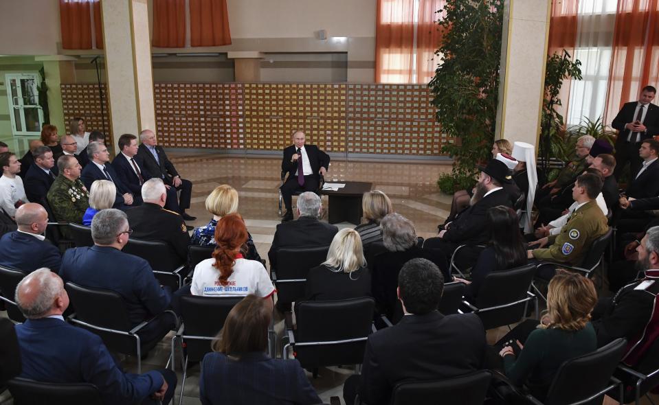 Russian President Vladimir Putin, center, speaks during a meeting with local residents in Simferopol, Crimea, Monday, March 18, 2019. Putin visited Crimea to mark the fifth anniversary of Russia's annexation of Crimea from Ukraine by visiting the Black Sea peninsula. (Yuri Kadobnov/Pool Photo via AP)