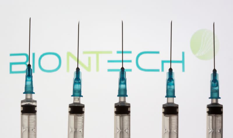 FILE PHOTO: Syringes are seen in front of a displayed Biontech logo in this illustration