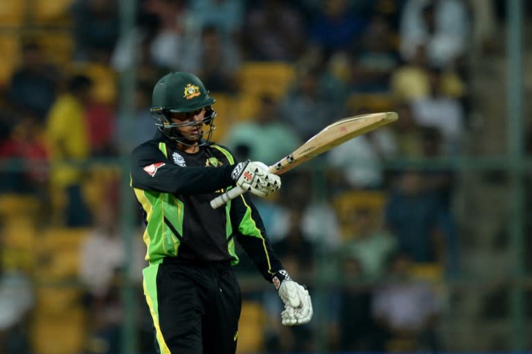 Australian batsman Usman Khawaja raises his bat after scoring 50 runs during the World T20 cricket tournament match between Australia and Bangladesh at The Chinnaswamy Stadium in Bangalore on March 21, 2016